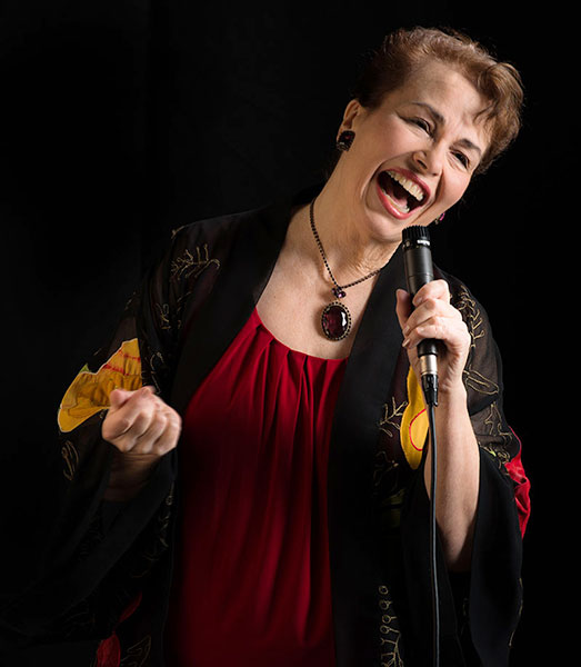 Cynthia Bythell singing into a mic